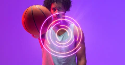 Composite of illuminated circular pattern over portrait of biracial basketball 스톡 사진