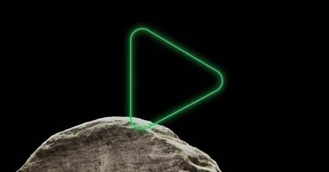 Composite of illuminated digital play button icon over rock against black Stock Photos