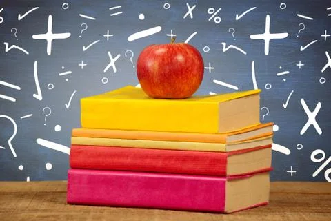 Composite image of apple with books on table Stock Photos