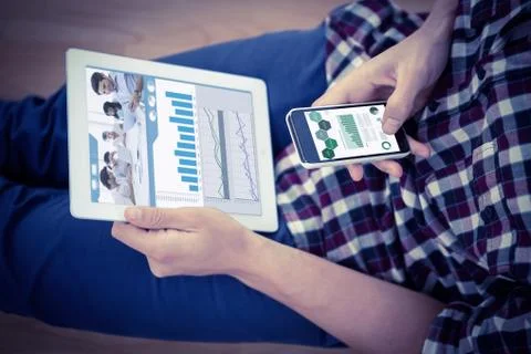 Composite image of attractive businessman using a tablet at work Stock Photos