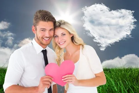 Composite image of attractive young couple holding pink heart Ilustração Stock