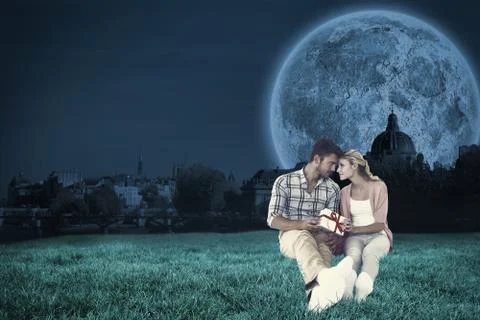 Composite image of attractive young couple sitting holding a gift Stock Illustration
