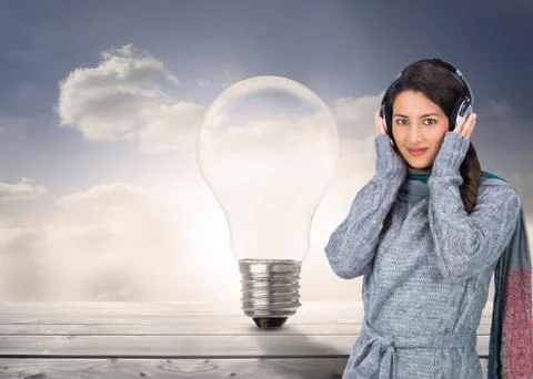 Composite image of beautiful model wearing winter clothes listening to music Illustrazione stock