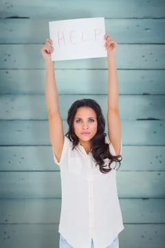 Composite image of brunette holding up help sign 스톡 사진