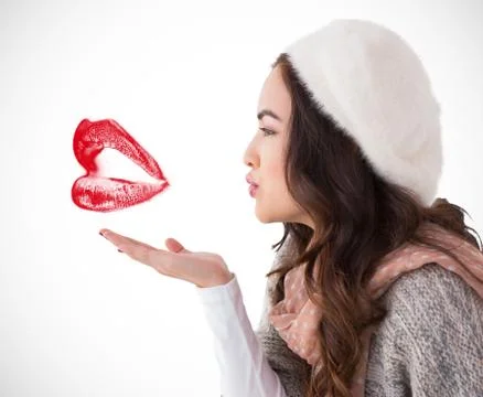 Composite image of brunette in winter clothes blowing kiss Illustrazione stock