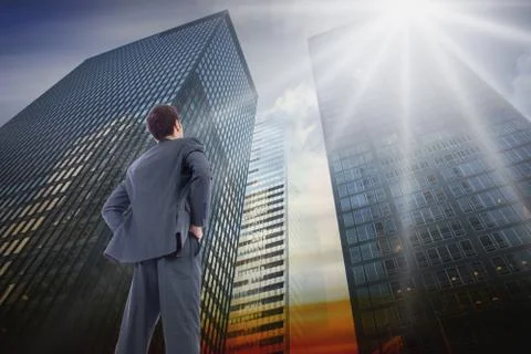 Composite image of businessman standing with hands on hips Ilustración de archivo