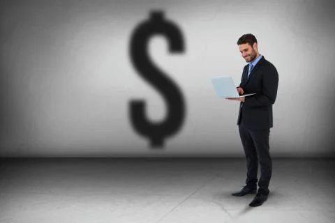 Composite image of businessman standing while using laptop computer Foto stock