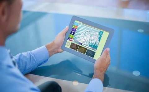 Composite image of businessman using his tablet Stock Photos