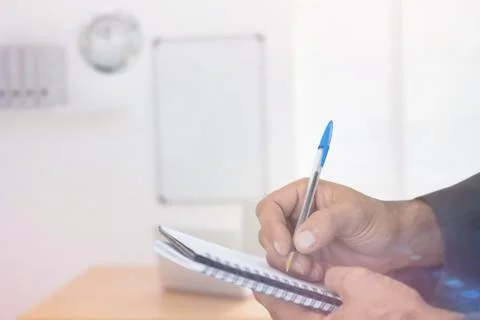 Composite image of close up of man writing in spiral book 写真素材