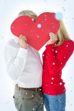 Composite image of couple embracing and holding heart over faces Ilustração Stock