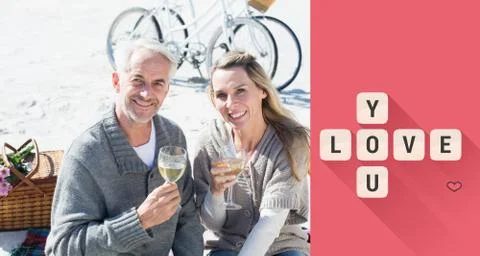 Composite image of couple enjoying white wine on picnic at the beach smiling at Ilustração Stock