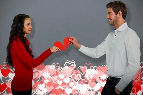 Composite image of couple holding red cracked heart shape Stock Photos