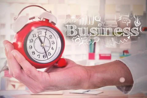 Composite image of cropped hand holding alarm clock Foto stock