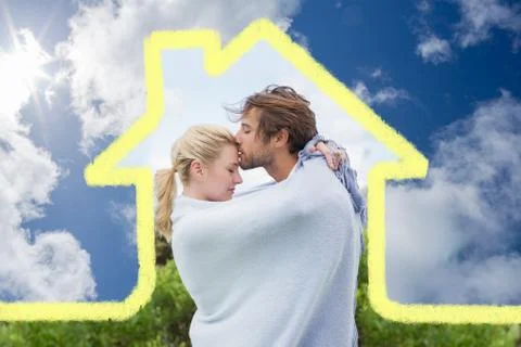 Composite image of cute affectionate couple standing outside wrapped in blanket Ilustración de archivo