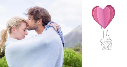 Composite image of cute affectionate couple standing outside wrapped in blanket Ilustración de archivo