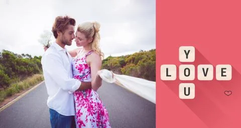 Composite image of cute couple standing on the road hugging Ilustração Stock