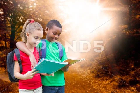 Composite image of cute pupils reading Stock Photos