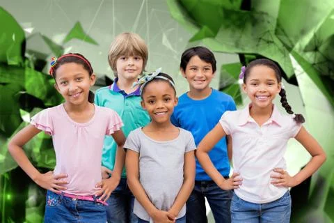 Composite image of cute pupils smiling at camera in classroom Foto stock