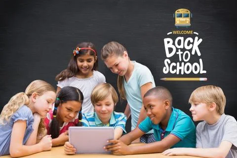 Composite image of cute pupils using tablet computer in library Foto stock