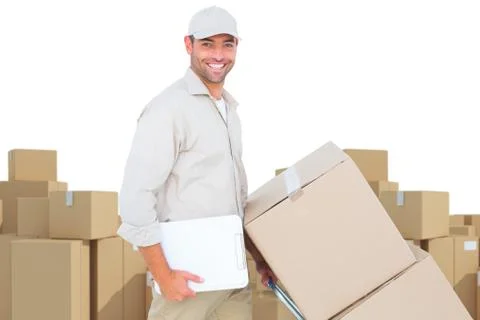 Composite image of delivery man pushing trolley of boxes on white background 库存照片