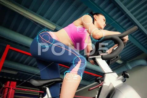 Composite image of determined young woman working out at spinning class Stock Photos