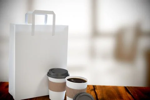 Composite image of disposable coffee cup and parcel bag Fotos de archivo