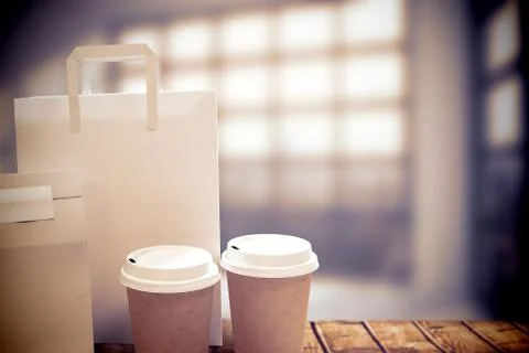 Composite image of disposable coffee cup and parcel bag Stock Photos
