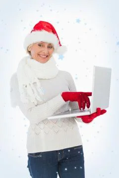Composite image of festive woman using laptop smiling at camera Illustrazione stock