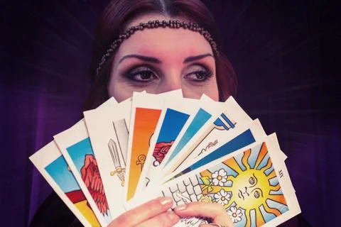 Composite image of fortune teller holding tarot cards while looking away Stock Photos