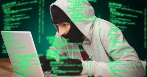 Composite image of hacker using laptop Foto stock