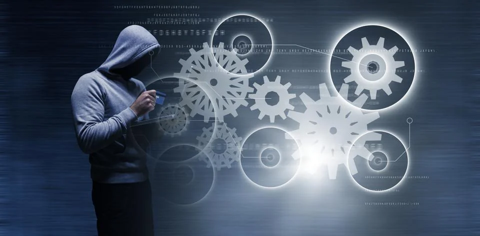 Composite image of hacker using laptop while holding credit card 写真素材