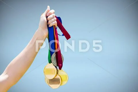Composite image of hand holding medals on white background Stock Photos