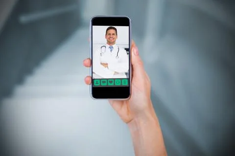 Composite image of hand holding mobile phone against white background Foto stock