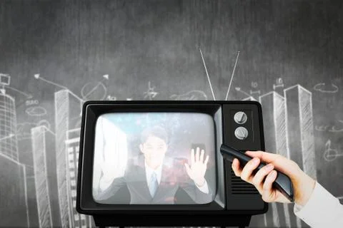 Composite image of hand using remote control Foto stock