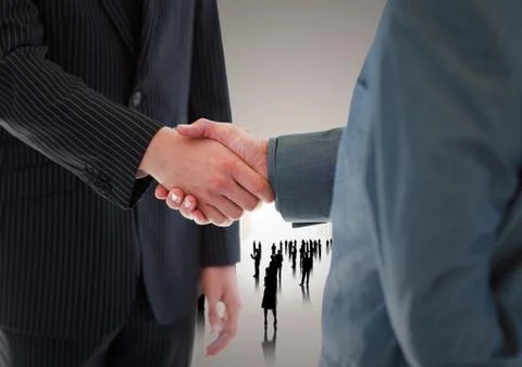 Composite image of Handshake in front of silhouette business people Foto stock