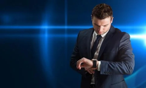 Composite image of handsome businessman checking the time Stock Photos