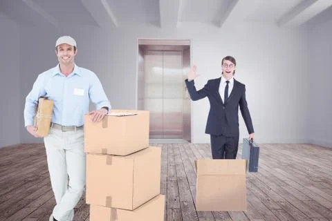 Composite image of handsome delivery man leaning on stacked cardboard boxes Stock Photos