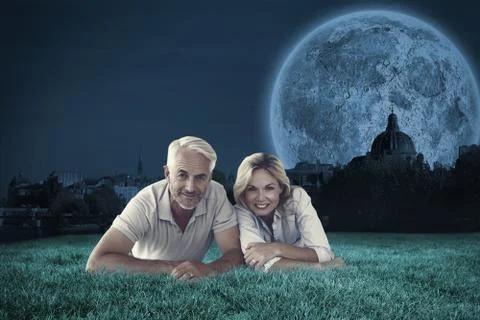 Composite image of happy couple lying smiling at camera Illustrazione stock