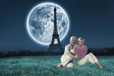 Composite image of happy couple sitting and holding heart pillow イラスト素材