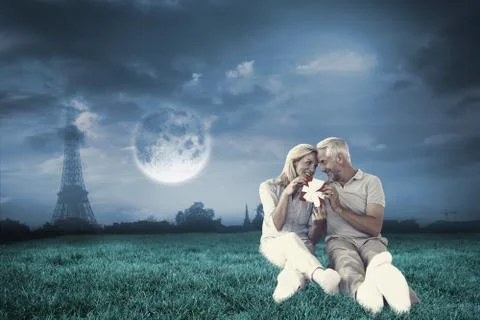 Composite image of happy couple sitting and holding present Stock Illustration