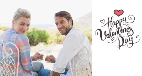 Composite image of happy young couple sitting in the garden enjoying wine Ilustração Stock