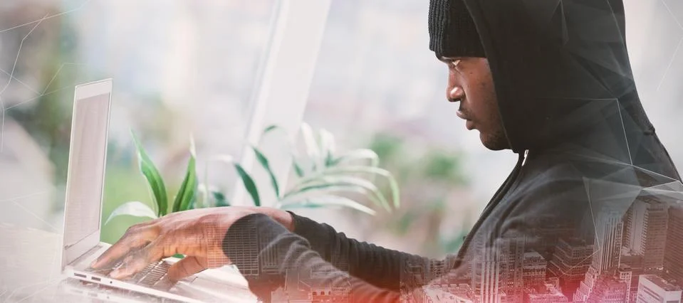 Composite image of male hacker using laptop Stock Photos