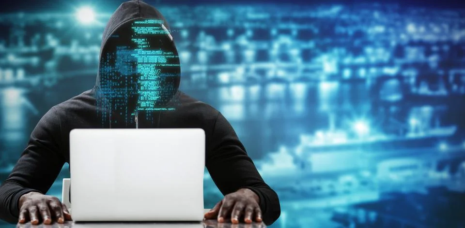 Composite image of male hacker using laptop on table Foto stock