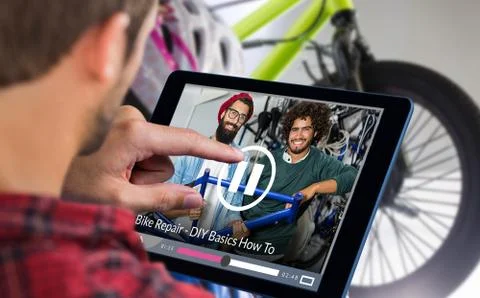 Composite image of man using tablet on wooden table Stock Photos