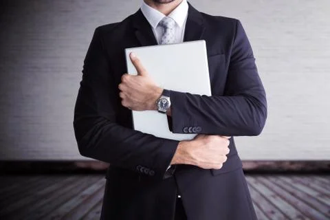 Composite image of mid section of businessman holding computer Foto stock