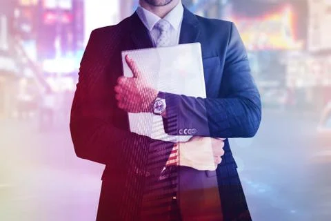 Composite image of mid section of businessman holding computer Fotos de archivo