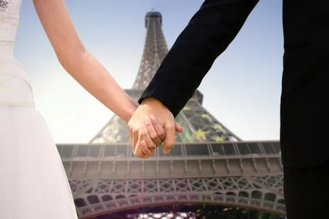 Composite image of mid section of newlywed couple holding hands in park Stock Photos