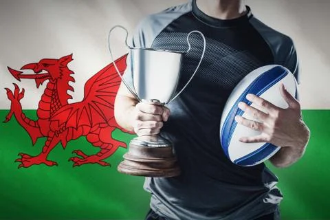 Composite image of midsection of successful rugby player holding trophy and ball Stock Photos