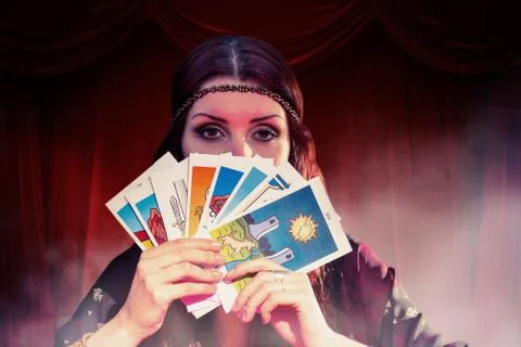 Composite image of portrait of fortune teller hiding mouth with tarot cards Stock Photos