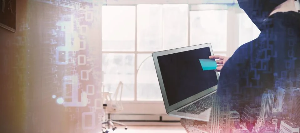 Composite image of rear view of hacker using laptop and credit card Stockfoto's